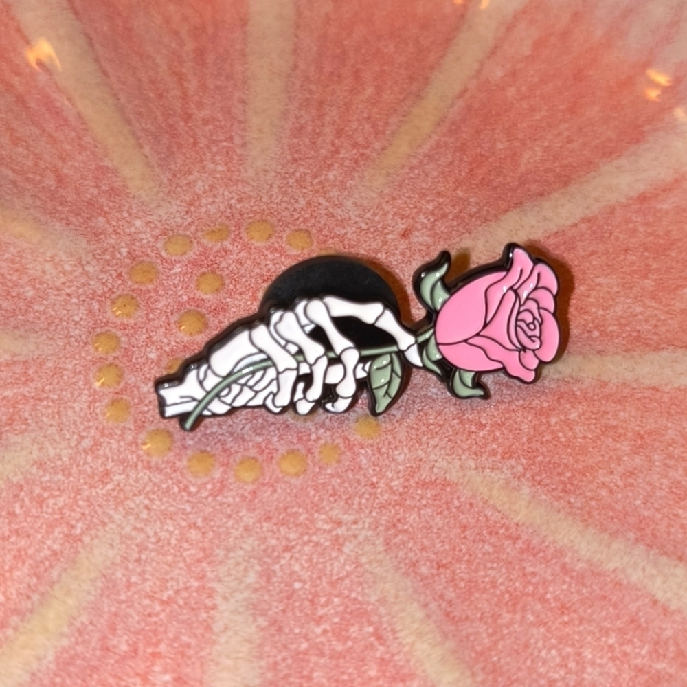 Black white and pink skeleton hand holding flower enamel pin clothes bag hat cap